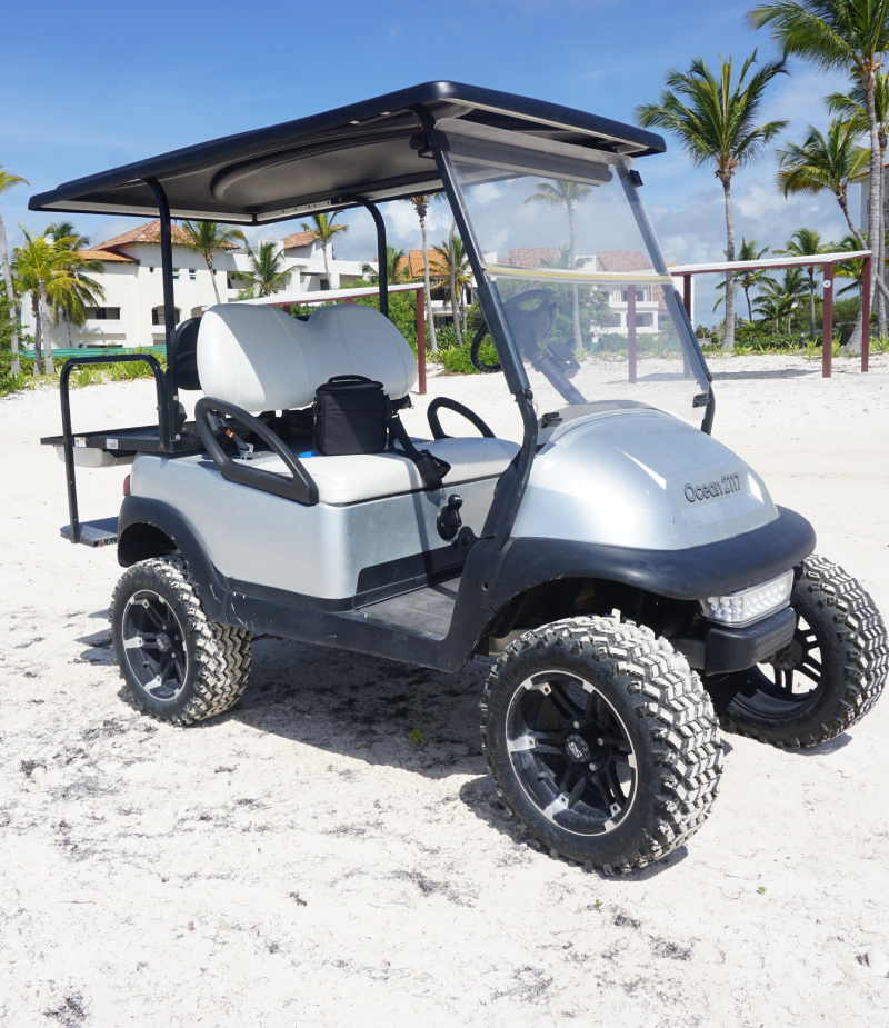 A golf cart is parked on the beach.