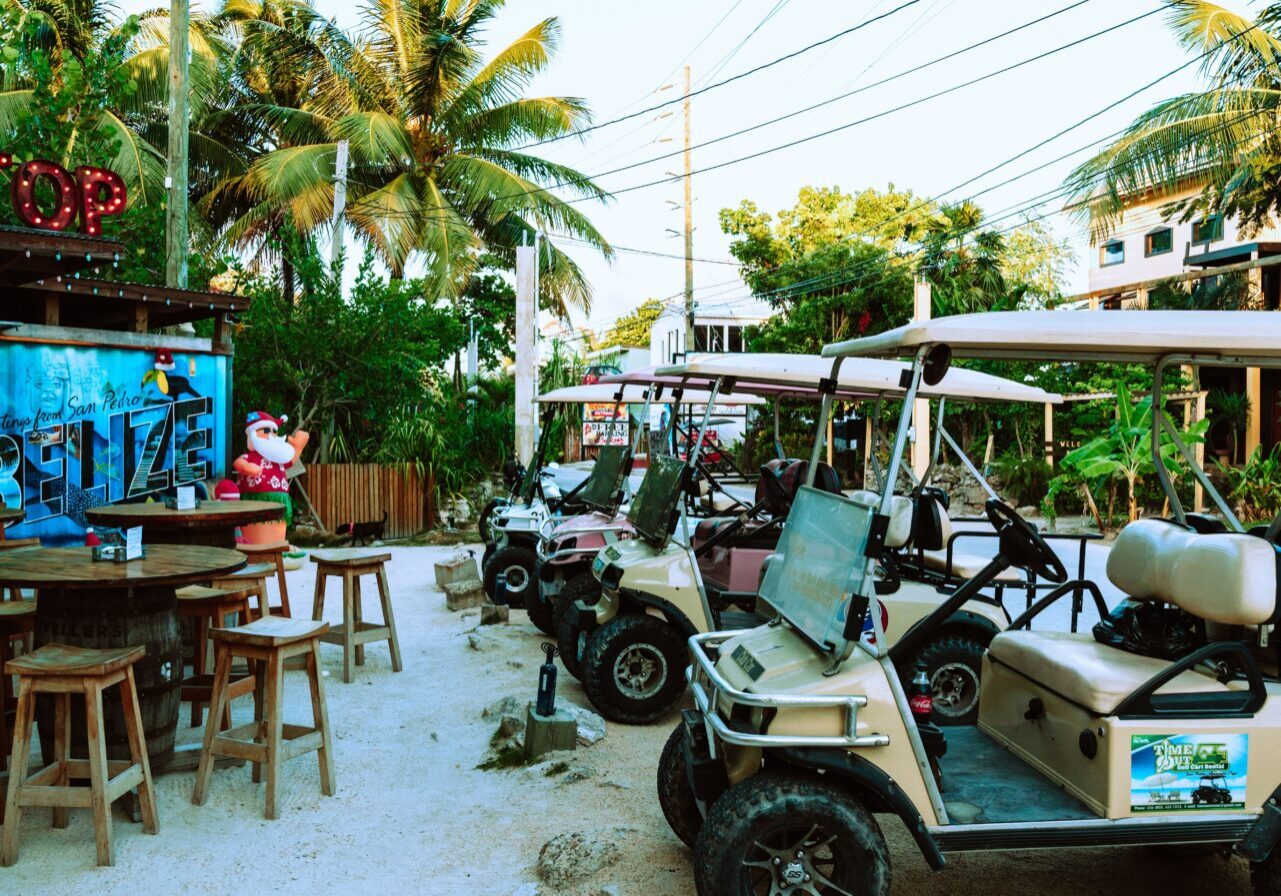 A group of golf carts parked in front of a bar.